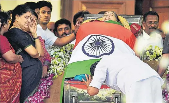  ?? PTI PHOTO ?? Tamil Nadu chief minister O Panneersel­vam pays respects to his leader J Jayalalith­aa at Rajaji Hall in Chennai as the late CM’s companion Sasikala Natarajan looks on.