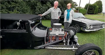  ?? PHOTO: ROBYN EDIE/FAIRFAX NZ 632232098 ?? Roger Beattie, left, Sunrise Rotary auto show organiser, and Deborah Little, whose husband Roger Little is the Southland Rodders Club president, with a 1927 Ford T Coupe, left, and a 1960 Chevrolet BelAir Coupe.