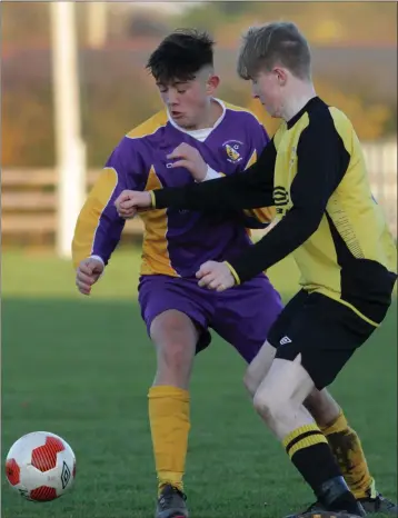 ??  ?? Ethan Vickers of the Wexford Football League battles for possession with Michael Byrne of the Kilkenny Football League.