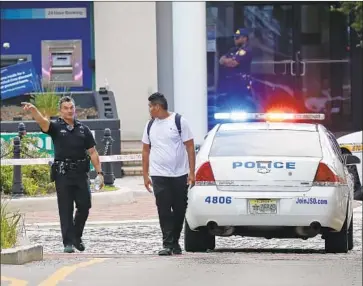  ?? John Raoux Associated Press ?? A PEDESTRIAN IS directed away from the scene of Sunday’s shooting at a video game tournament in Jacksonvil­le, Fla. Police said David Katz, 24, killed two people and himself after he was defeated earlier in the event.