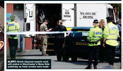  ??  ?? ALERT: Bomb disposal experts work with police in Manchester’s Moss Side yesterday as fresh arrests were made