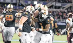  ??  ?? Oklahoma State running back Justice Hill celebrates with teammates after scoring a first-half touchdown during the Cowboys’ 30-21 win over Virginia Tech in the Camping World Bowl on Thursday in Orlando, Florida. [PHOTO BY BRUCE WATERFIELD, COURTESY OSU...