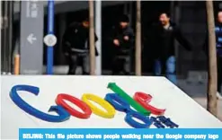 ?? —AFP ?? BEIJING: This file picture shows people walking near the Google company logo outside the former Google China headquarte­rs in Beijing.