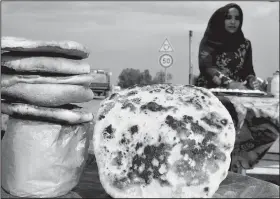  ??  ?? Marwa Harch makes and sells bread and sandwiches on a highway in Kairouan, a Tunisian city famous in Islamic history.