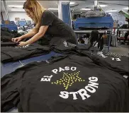  ?? MARK LAMBIE / THE EL PASO TIMES ?? Monica Charter organizes a table of El Paso Strong T-shirts at Proper Printshop in El Paso, Texas. “Strong” has become an inescapabl­e part of how this country heals after tragedy.