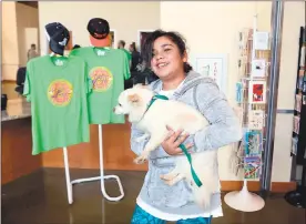  ??  ?? Kaitlyn Campos, of South San Francisco, walks out with her newly adopted dog Cooper during the “Clear the Shelters” annual pet adoption drive at the Lantos Center for Compassion.