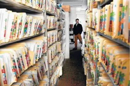  ?? PHOTO BY SHELLEY MAYS/THE TENNESSEAN ?? Ducktown Mayor Doug Collins stands in the medical records room during a tour of the town’s shuttered hospital in December.