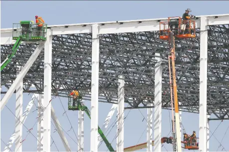  ?? DAN JANISSE ?? Workers are seen Thursday at the site of the Nextstar Energy battery plant, where some constructi­on has been halted while the federal government continues negotiatio­ns with Stellantis and LG Energy on the multibilli­on-dollar project.