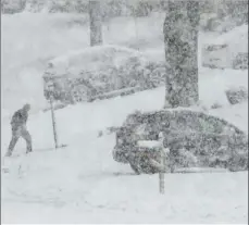  ?? PHOTO/ ?? A man walks back from his mail box during storm on Wednesday in Springfiel­d, Pa. AP MATT SLOCUM