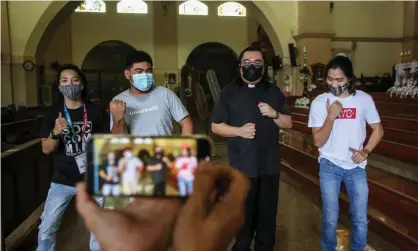  ?? Photograph: Jam Sta Rosa/AFP/Getty Images ?? Teens in the Philippine­s teaching a priest a TikTok dance at church.