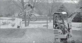  ?? Ben Goff/NWA Democrat-Gazette ?? Hardy Clyatt, of Fayettevil­le, with Progressiv­e Trail Design makes a test ride as Garrick Topp of Topp Trails, a division of Progressiv­e Trail Design, from South Lake Tahoe, Calif., runs a mini excavator on Jan. 30 while building a pump track at...