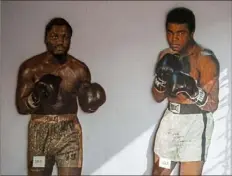  ??  ?? Cardboard cutouts of boxers Joe Frazier, left, and Muhammad Ali at Heist in Dormont.