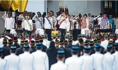  ??  ?? Sultan Muhammad V in red sash saluting the guard of honour from the 1st Battalion of the Royal Malay Regiment at Dataran Pahlawan Negara in Putrajaya during a parade in conjunctio­n with the 2018 Warriors’ Day celebratio­n.