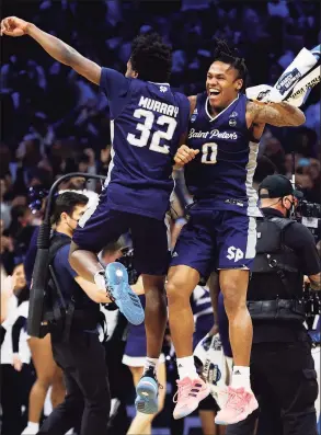  ?? Tim Nwachukwu / Getty Images ?? St. Peter’s Jaylen Murray (32) and Latrell Reid celebrate after defeating Purdue on Friday in Philadelph­ia.