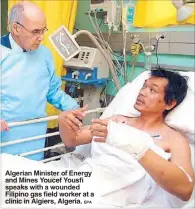  ?? EPA ?? Algerian Minister of Energy and Mines Youcef speaks with wounded Filipino gas field worker at a clinic in Algiers, Algeria.