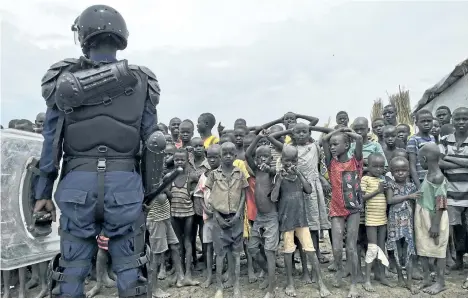  ?? SAM MEDNICK/THE ASSOCIATED PRESS ?? A crowd of displaced people look on as members of the UN multi-national police contingent provide security during a visit of UNCHR High Commission­er Filippo Grandi to South Sudan’s largest camp for the internally-displaced, in Bentiu, South Sudan Sunday.