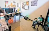  ?? CRAIG MITCHELLDY­ER/AP ?? Katie Arnold works in her office in Portland, Oregon, while her 7-year-old son, Rowen, plays educationa­l games.