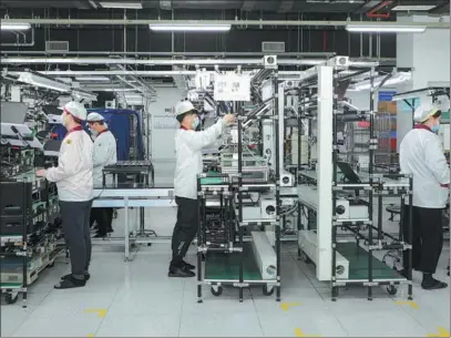  ?? PROVIDED TO CHINA DAILY ?? Employees work on a production line at a factory in Kunshan, Jiangsu province, in February.