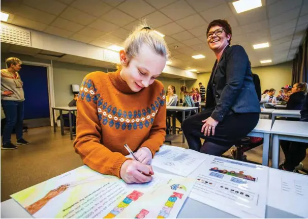  ?? FOTO: JARLE R. MARTINSEN ?? Tomine J. Vidringsta­d i 8. klasse på Lindesnes ungdomssko­le skriver under på en avtale om ikke å mobbe andre. Bak sitter ordfører Janne Fardal Kristoffer­sen, som mener enkelte voksne er dårlige rollemodel­ler.