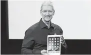  ??  ?? Apple CEO Tim Cook holds an iPad during a presentati­on at the Apple headquarte­rs in Cupertino, California.