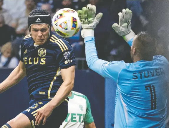  ?? ETHAN CAIRNS/THE CANADIAN PRESS ?? Austin FC goalkeeper Brad Stuver stops Bjorn Utvik of the Vancouver Whitecaps during the second half of their Major League Soccer match on Saturday in front of a record crowd of 32,465 at B.C. Place. The game ended in a scoreless draw .