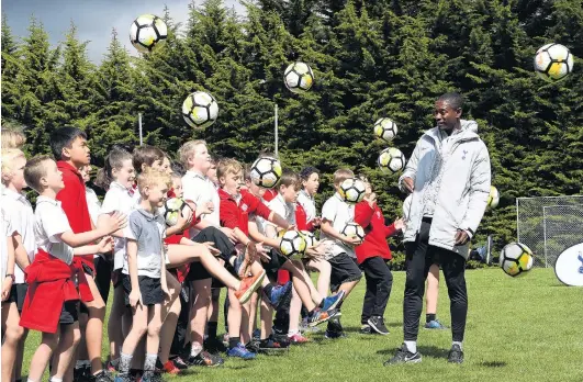  ?? PHOTO: STEPHEN JAQUIERY ?? Football barrage . . . Tottenham Hotspur internatio­nal developmen­t coach Anton Blackwood shows the pupils of Fairfield School some tricks yesterday.