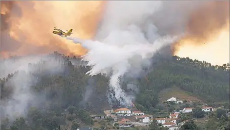  ?? Pablo Blazquez Dominguez Getty Images ?? A FIREFIGHTI­NG plane at work over the Mega Fundeira area of Pedrogao Grande in central Portugal, where fires started Saturday.