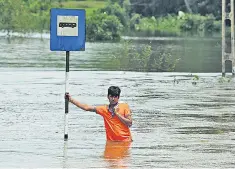  ??  ?? A man stands amid flooding in Kalutara district after the worst rain in Sri Lanka since 2003