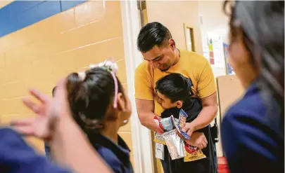  ?? Jon Shapley / Staff photograph­er ?? Sanchez Elementary resource specialist Alejandro Martinez gives a snack and hug to Nathan Ayala on his birthday.