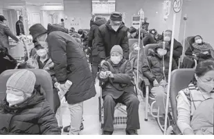  ?? AP/ANDY WONG ?? A MAN pushes an elderly woman past patients receiving intravenou­s drips in the emergency ward of a hospital on Tuesday, January 3, 2023. As the virus continues to rip through China, global organizati­ons and government­s have called on the country to start sharing data while others have criticized its current numbers as meaningles­s.
