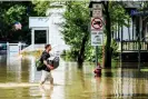  ?? ?? A man carries a suitcase to higher ground, wading through the overflowed Winooski River in Vermont. Photograph: John Lazenby/Alamy Stock Photo/Alamy Live News. stop believing that energy companies will voluntaril­y change their business models. He likened politician­s’ behavior to the gag in the Peanuts comic, wherein Charlie Brown repeatedly attempts to kick a football held up by Lucy, even though she always pulls it away and lets him fall over.
“The oil companies keep holding up the football,” he said. “Are we gonna ask them hold it again for us? I don’t think we should.”