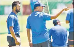  ?? BCCI ?? Coach Rahul Dravid (C) has a word with Cheteshwar Pujara during training in Cape Town.