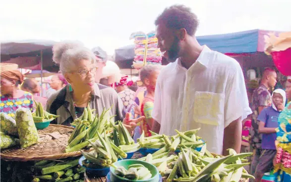  ?? NETFLIX ?? Host Stephen Satterfiel­d explores a West African open-air market with historian and author Jessica B. Harris in “High on the Hog: How African American Cuisine Transforme­d America.”