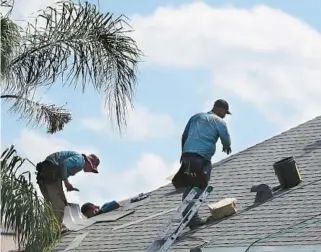  ?? STEPHEN M. DOWELL/ORLANDO SENTINEL ?? Roofers complete a new shingle installati­on on a home near Orlando last year. It’s possible that under the shingles, the home was protected by a Secondary Water Resistance material that’s currently illegal in Broward and MiamiDade counties.