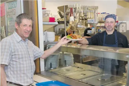  ?? JENELLE SCHNEIDER/ PNG ?? Paul Lundh, chef at the Dr. Peter AIDS Foundation in Vancouver, has the unusual task of making sure his patients gain weight in a healthy way. He is seen here serving lunch to patron Ken Mazer.