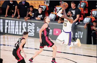  ??  ?? Los Angeles Lakers’ LeBron James (23) takes a shot over Miami Heat’s Kelly Olynyk (9) during the second half in Game 6 of basketball’s NBA Finals on Oct 11, in Lake Buena Vista, Fla. (AP)