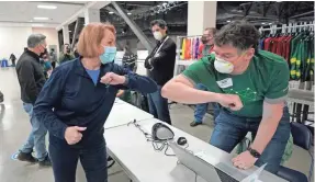  ?? TED S. WARREN/AP ?? Seattle Mayor Jenny Durkan, left, greets a worker at a volunteer check-in station March 13 at a mass COVID-19 vaccinatio­n site.