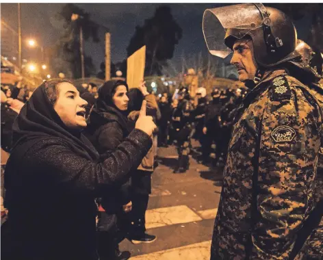  ?? FOTO: AFP ?? Eine Frau redet am Rande einer Trauerfeie­r für die Opfer des abgeschoss­enen ukrainisch­en Passagierj­ets auf einen Polizisten ein.