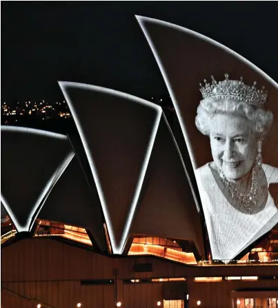  ?? ?? Rememberin­g her Down Under: An image of Queen Elizabeth II is projected on to the sails of the Sydney Opera House after a 96-gun salute in Canberra yesterday