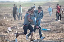  ?? AP ?? An injured protester is carried to safety at the Gaza border.