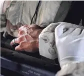  ?? PROVIDED ?? A close- up of then- Sgt. Jim Rudisill’s hand, with another person’s gloved hand holding his wrist, as he is medically evacuated from Diyala Province, Iraq, in 2005. He suffered multiple injuries and says he also saw the toll war took on his comrades.