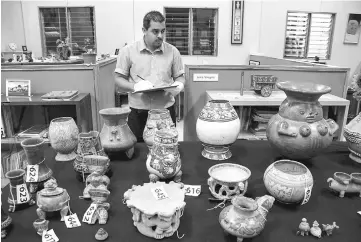  ??  ?? An employee at the National Museum checks pre-Columbian pieces, which had been taken out of the country illegaly to Venezuela and were now returned by the Venezuelan government, in San Jose, Costa Rica. — AFP photo