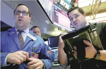  ?? — Reuters ?? Traders work on the floor of the New York Stock Exchange (NYSE) in New York.