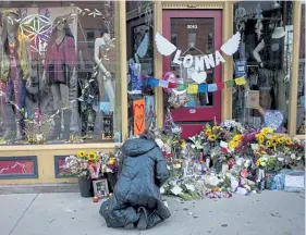  ?? Timothy Hurst, Daily Camera Staff Photograph­er ?? A mourner drops off flowers at a memorial for Tralona Lynn “Lonna” Bartkowiak, one of the victims of Monday’s mass shooting, in front of Umba, the store that Bartkowiak founded, on Wednesday, March 24, in Boulder.