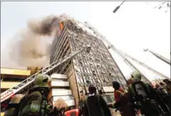  ?? STRINGER/AFP ?? Firefighte­rs battle the blaze that engulfed Iran’s oldest high-rise in Tehran before it collapsed yesterday.