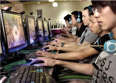  ??  ?? Online zombies: A line of dead-eyed Chinese youths play computer games at an internet cafe