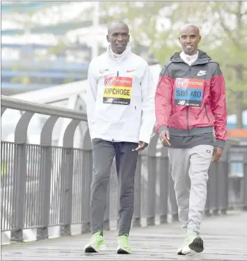  ??  ?? Men’s elite runners Kenya’s Eliud Kipchoge (left) and Britain’s Mo Farah pose during a photocall for the London marathon at Tower Bridge in central London. — AFP photo