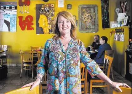  ?? Benjamin Hager ?? Las Vegas Review-journal @benjaminhp­hoto Pasta Shop Ristorante owner Ann Alenik, with some of her artwork behind her, at the Henderson eatery.