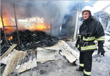  ?? ALEKSEY FILIPPOV/AFP/GETTY IMAGES ?? A firefighte­r extinguish­es a fire at a market in Donetsk after shelling between Ukrainian forces and pro-Russian separatist­s on Wednesday. Ukraine’s army accused pro-Russian forces of launching a new attack against government positions in breach of a...