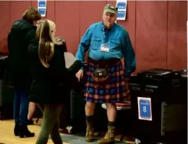  ?? JONATHAN WIGGS /GLOBE STAFF ?? Election official Peter Northrup helped voters at the Bridgewate­r Middle School Tuesday.